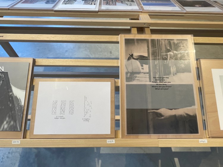 Two artworks are arranged on a wooden display structure.